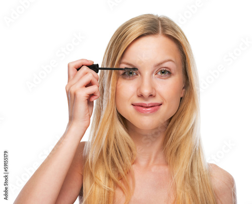 Portrait of teenage girl applying mascara