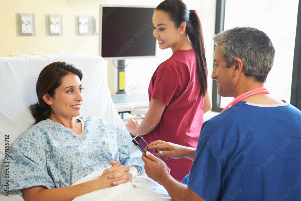 Male Nurse Talking With Female Patient In Hospital Room