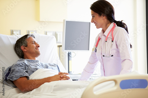 Female Doctor Talking To Male Patient In Hospital Room © Monkey Business