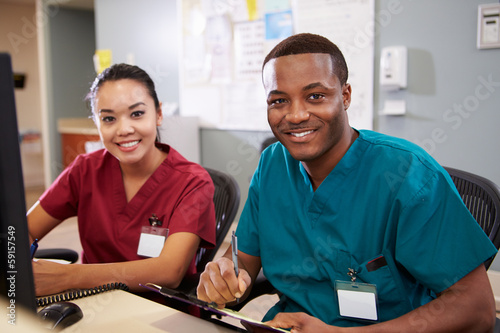 Male And Female Nurse Working At Nurses Station photo