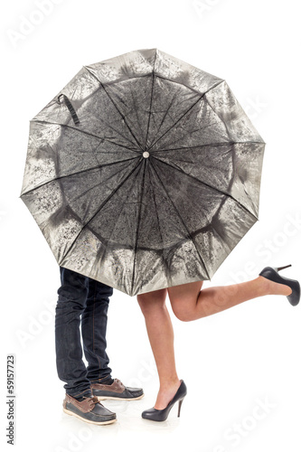 Female and man's legs under a umbrella