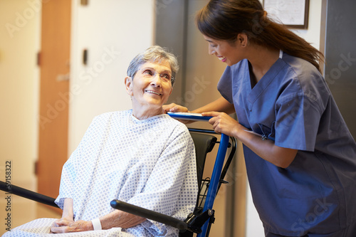 Fotografía Senior Female Patient Being Pushed In Wheelchair By Nurse
