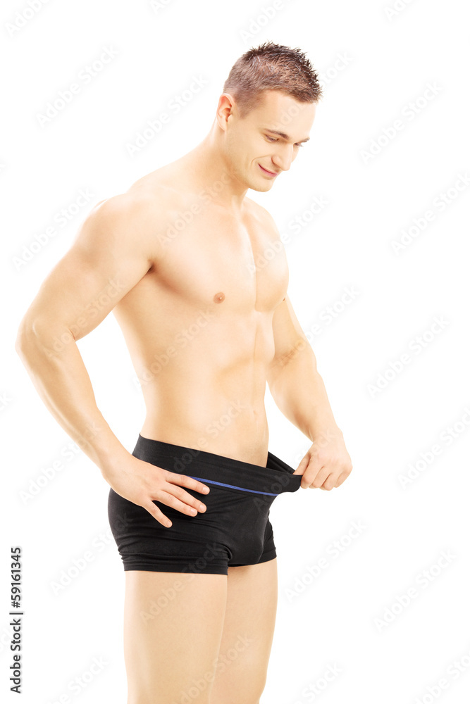 Young shirtless man looking in his pants Young shirtless man looking in his pants