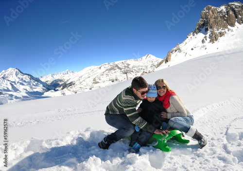 family having fun on fresh snow at winter vacation