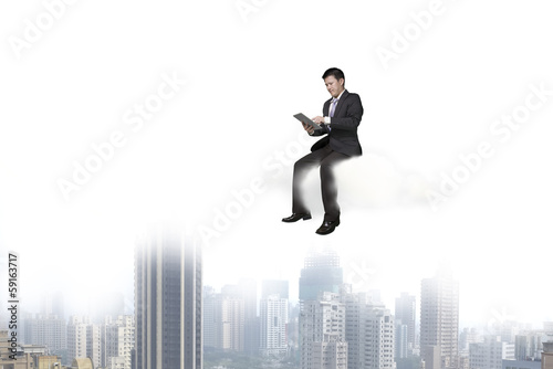 Businessman using tablet and sitting on cloud © TSUNG-LIN WU