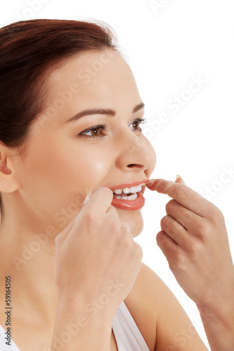 Beautiful young woman with dental floss.