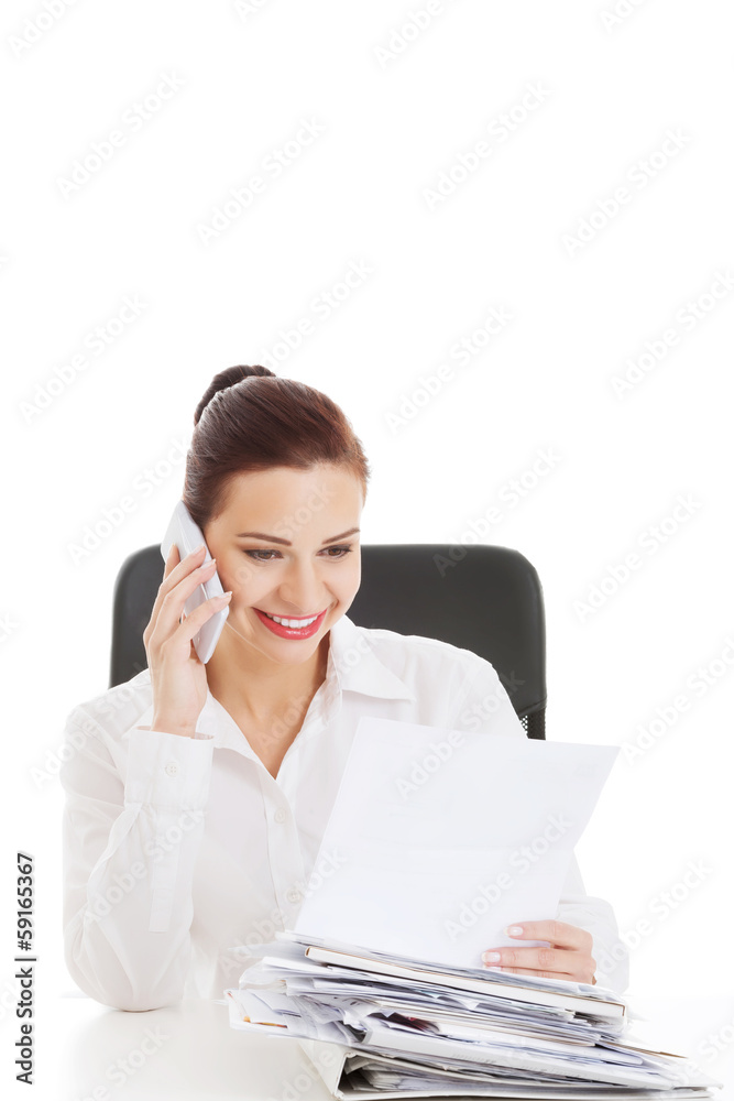 Beautiful business woman sitting and talking through phone.