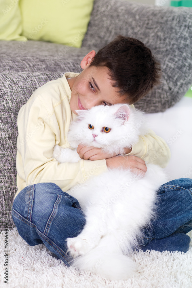 boy with a white Persian cat at home