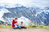 A teenager boy, toddler girl and newborn baby in mountains