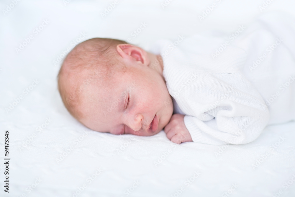 Little newborn baby boy sleeping on a white knitted blanket Little newborn baby boy sleeping on a white knitted blanket