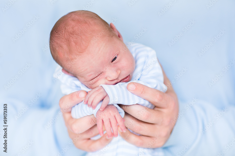 Cute tiny newborn baby boy sleeping in his father's hands Cute tiny newborn baby boy sleeping in his father's hands