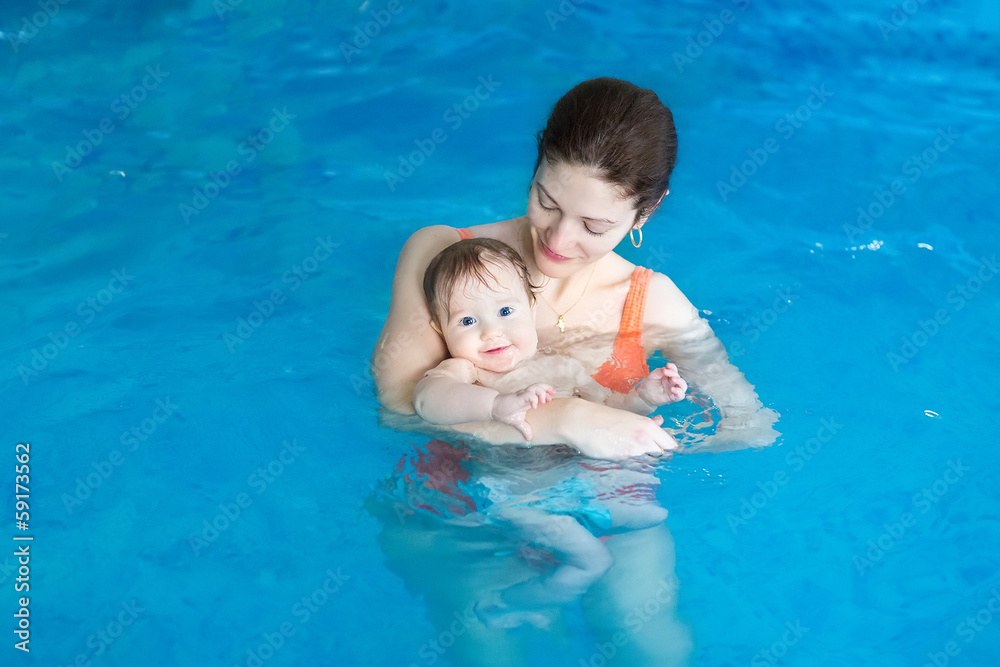 Mother and her baby in a swimming lesson in the swimming pool