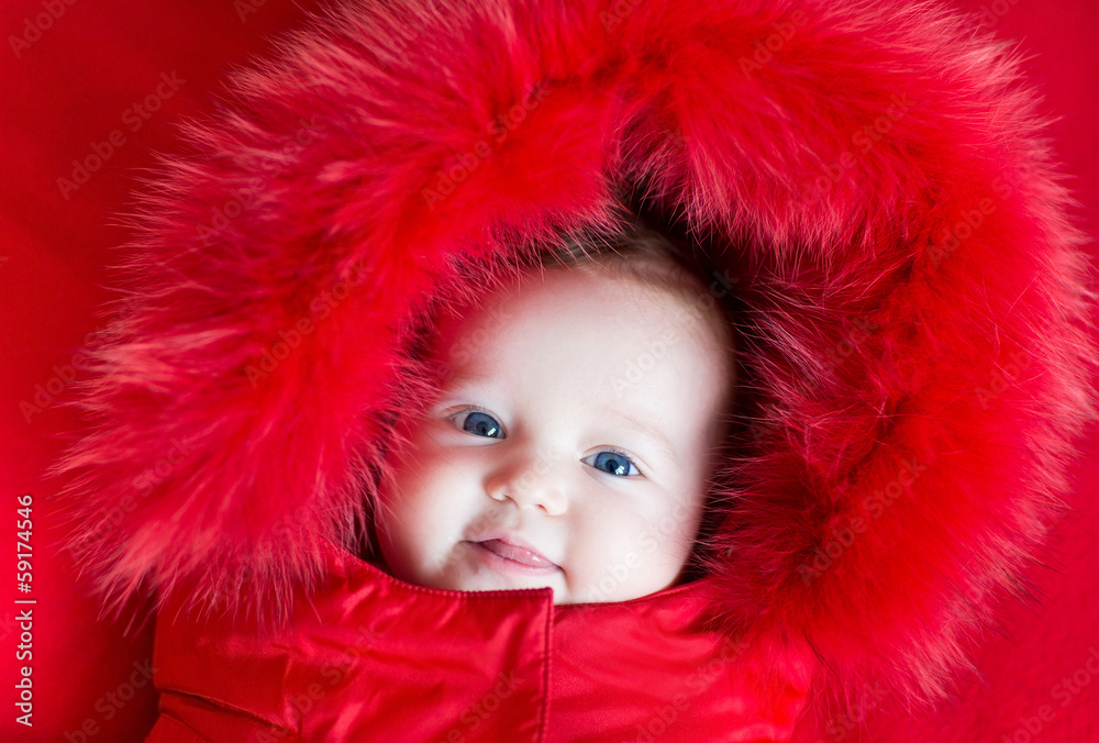 Cute funny baby girl with big blue eyes in a warm winter jacket Cute funny baby girl with big blue eyes in a warm winter jacket