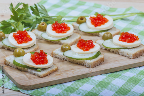 Sandwiches of white bread with fresh cucumber, cheese, salmon c