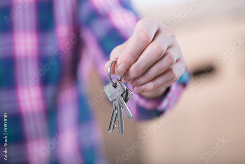 Frau zeigt Schlüssel für Wohnung