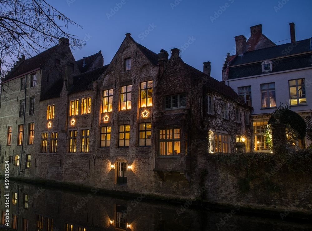 House with Christmas stars at night in Bruges, Belgium