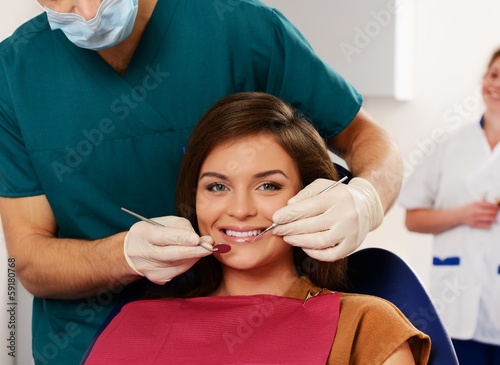 Woman and man doctor with his assistant at dentist s surgery