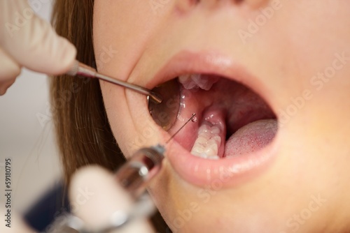 Dentist making anaesthetic injection to woman patient photo