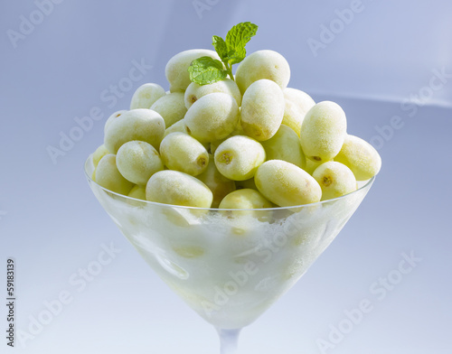 Frozen grape in martini glass.