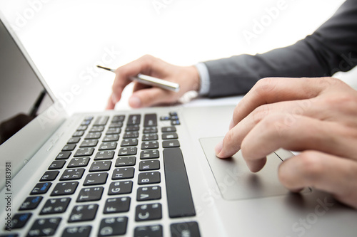 Close-up of male hands typing on laptop