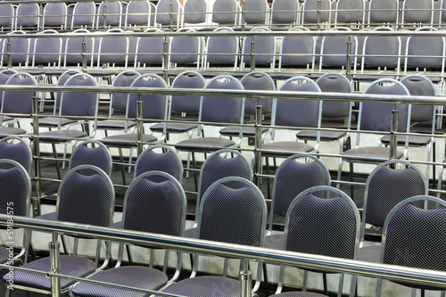 Принти на полотні Rows of simple chairs with handrails in modern hall