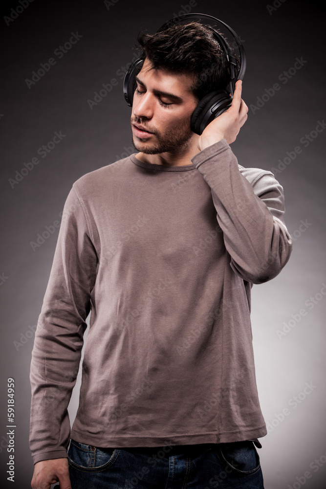 Man is listening to music while wearing headphones
