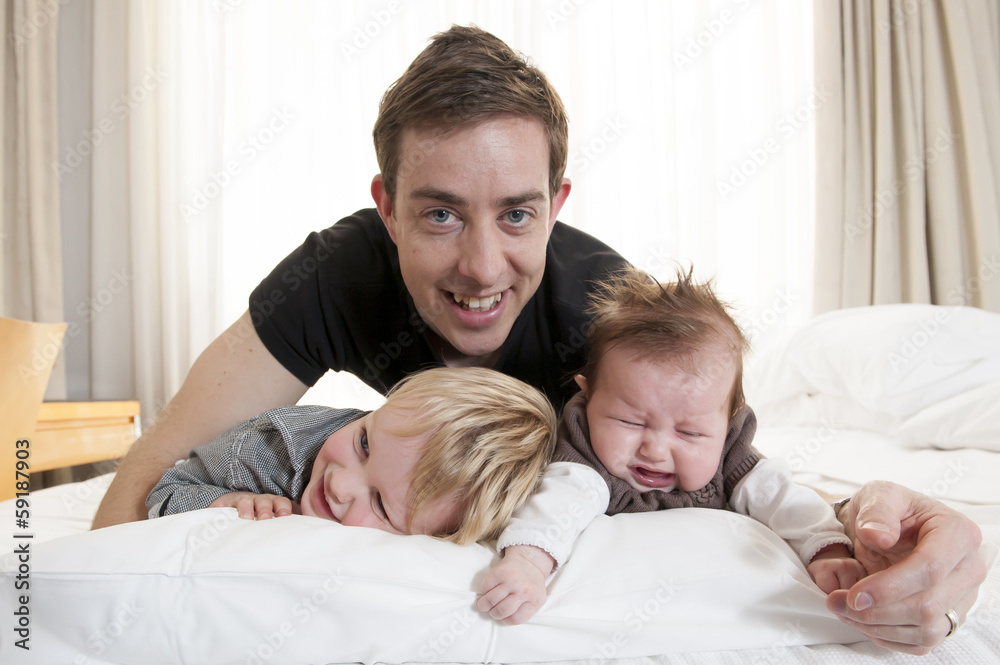 Fototapeta premium Young father playing with sweet baby girl and son