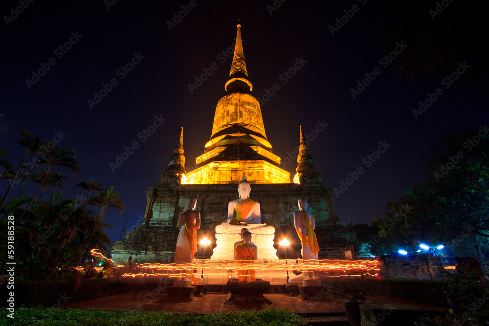 Fototapeta premium Walking with lighted candles in hand around a temple in Thailand