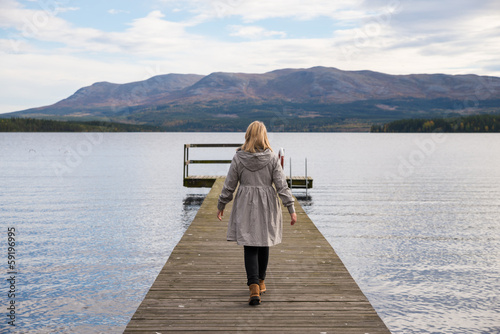 lonely woman walking on a pier