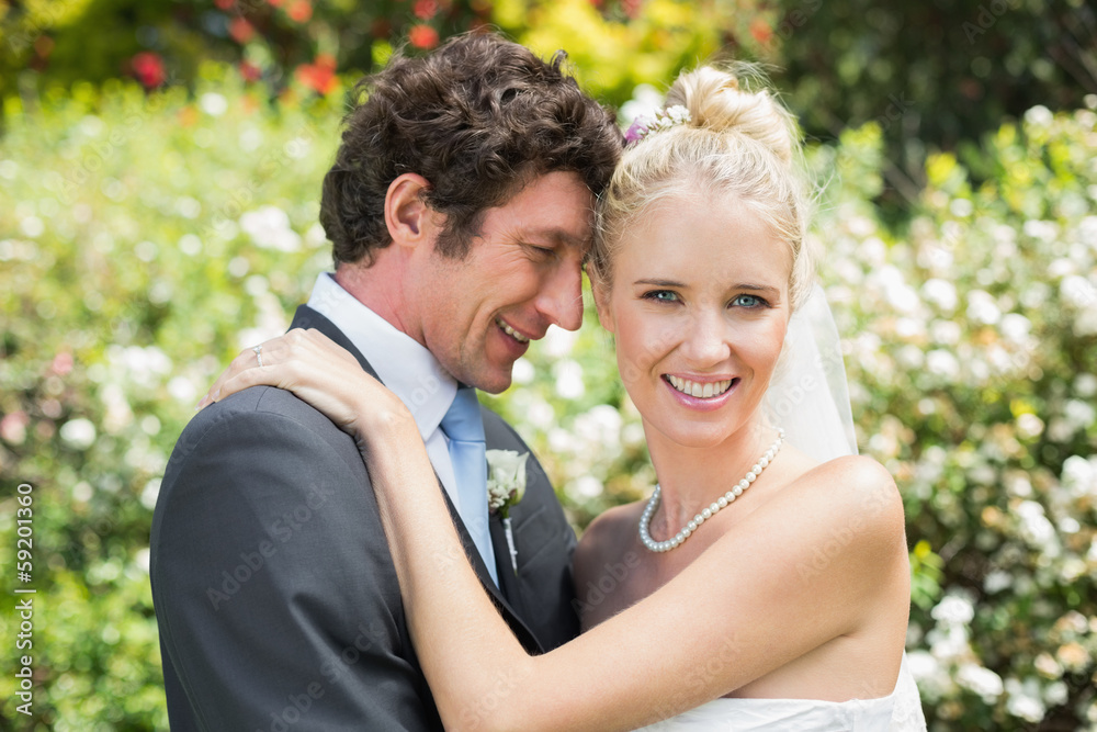 Romantic smiling newlyweds hugging each other