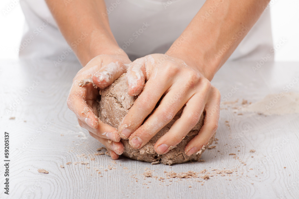 hands knead rye dough