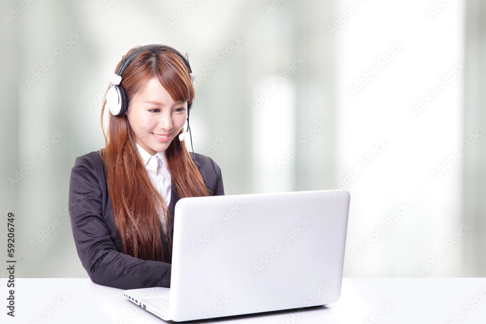 female in suit typing on her laptop and using headphones female in suit typing on her laptop and using headphones