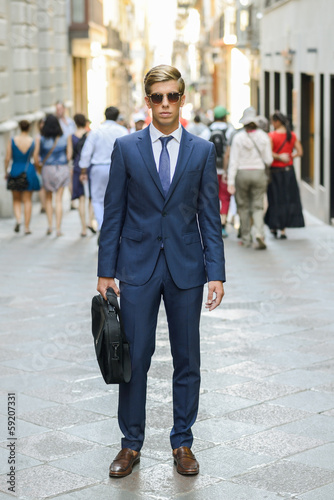 Attractive young businessman in urban background