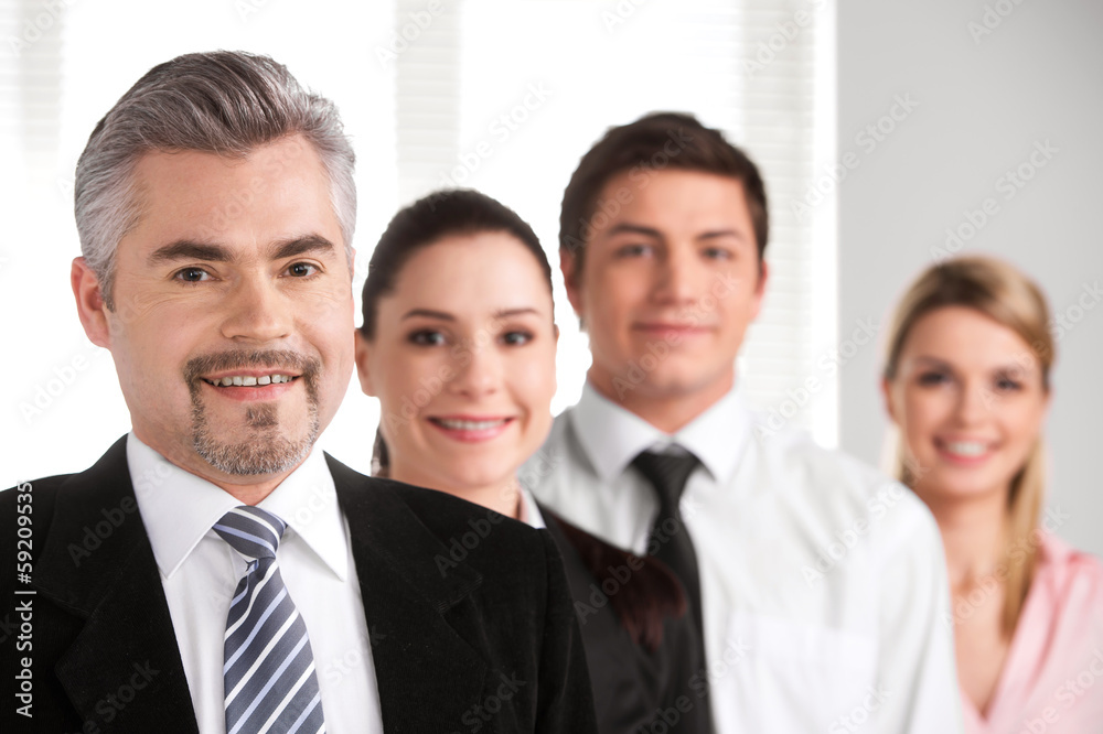 Close up of successful adult businessman leading business team. Close up of successful adult businessman leading business team.