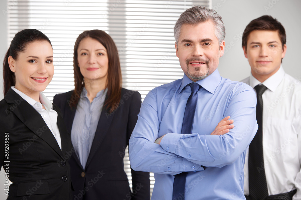 senior businessman standing on foreground and smiling. senior businessman standing on foreground and smiling.