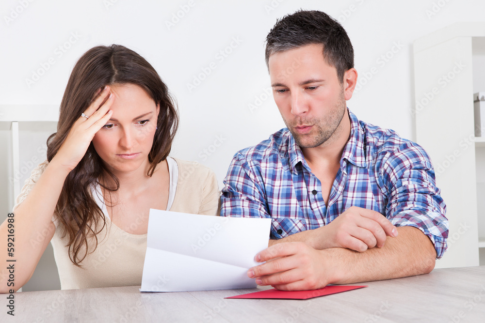 Worried Couple Reading Paper Worried Couple Reading Paper