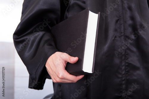 Male Judge Holding Law Book