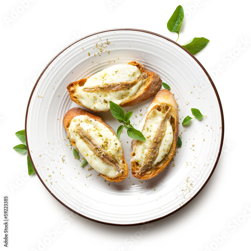 Crostini with anchovy and mozzarella on the white background