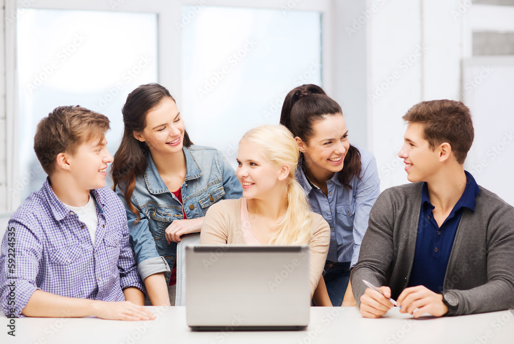 smiling students with laptop at school