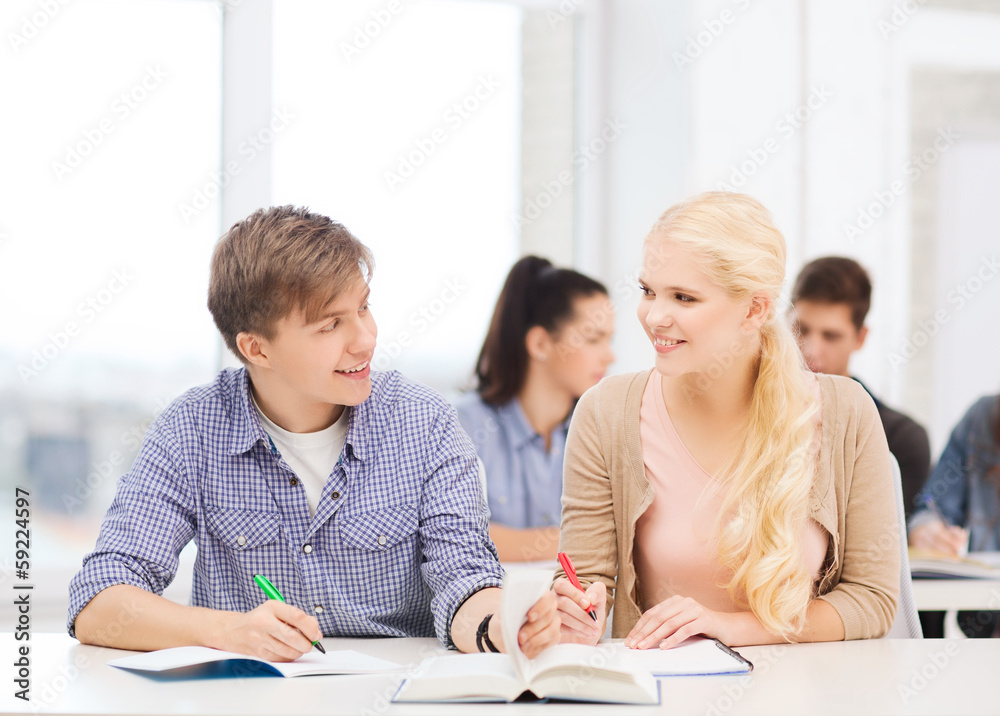 © Syda Productions - two teenagers with notebooks and book at school
