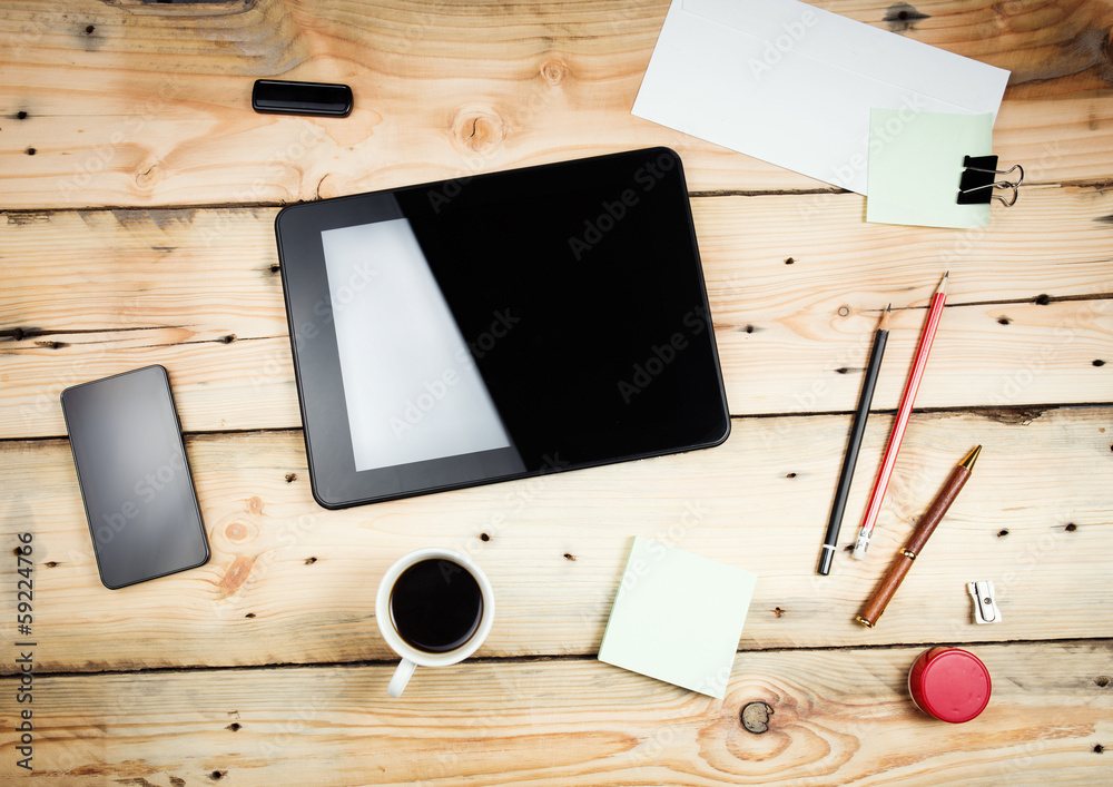 Workplace, tablet pc and smart phoned on wooden table Workplace, tablet pc and smart phoned on wooden table