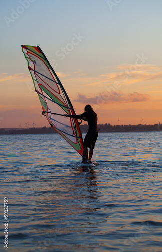 windsurfer on the calm water and red sky