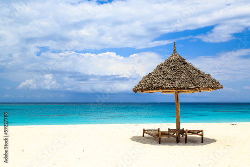 Beds and umbrella on a white sand beach