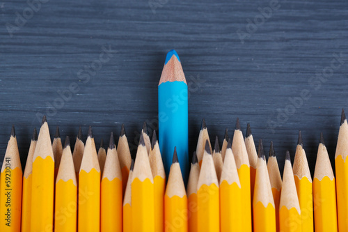 Celebratory pencil among usual pencils, on color background