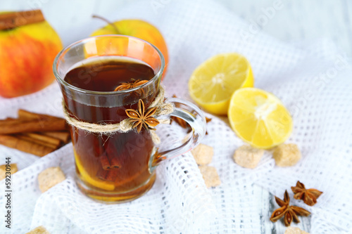 Hot beverage in glass cup with fruits and spices,