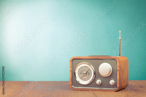 Retro style radio receiver on table front mint green background photo