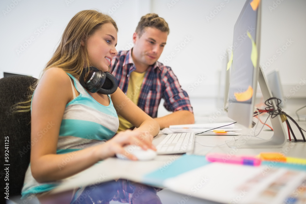 Fototapeta premium Cheerful classmates doing an assignment together in the computer