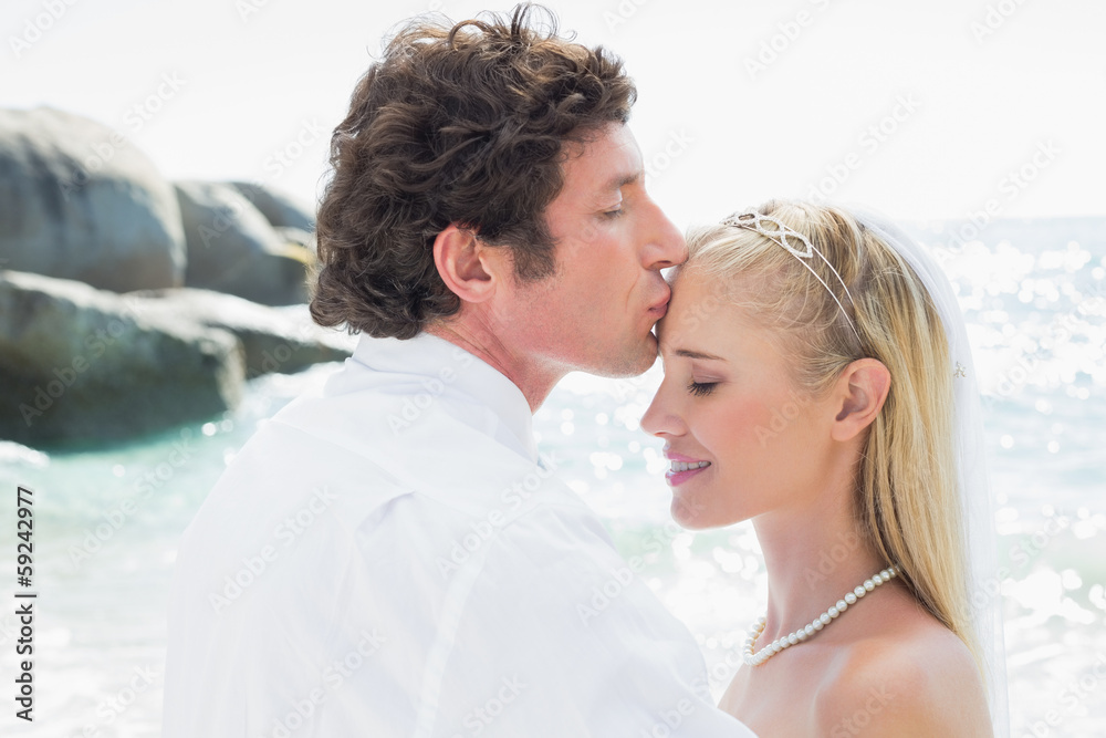 Groom kissing his pretty new wife on forehead Groom kissing his pretty new wife on forehead
