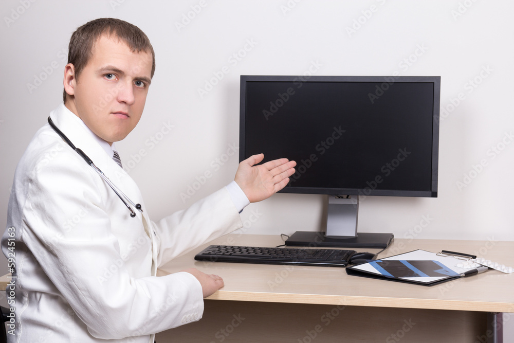 young male doctor pointing at computer screen young male doctor pointing at computer screen