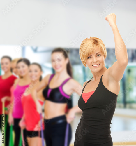 Fototapeta Naklejka Na Ścianę i Meble -  group of smiling people exercising in the gym